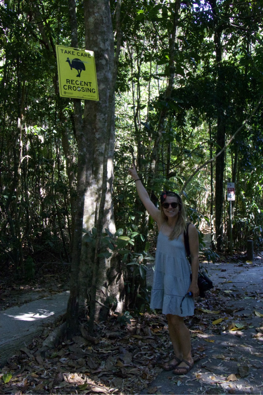 Sarah pointing to a sign stating there has been a recent cassowary crossing.